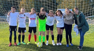 Konfirmanden vor einem Tor in Fußballtrikots